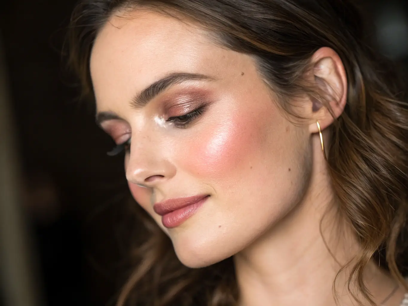 A close-up shot of a model showcasing the 'glass skin' trend, with dewy, radiant skin and minimal makeup, set against a soft, diffused background.