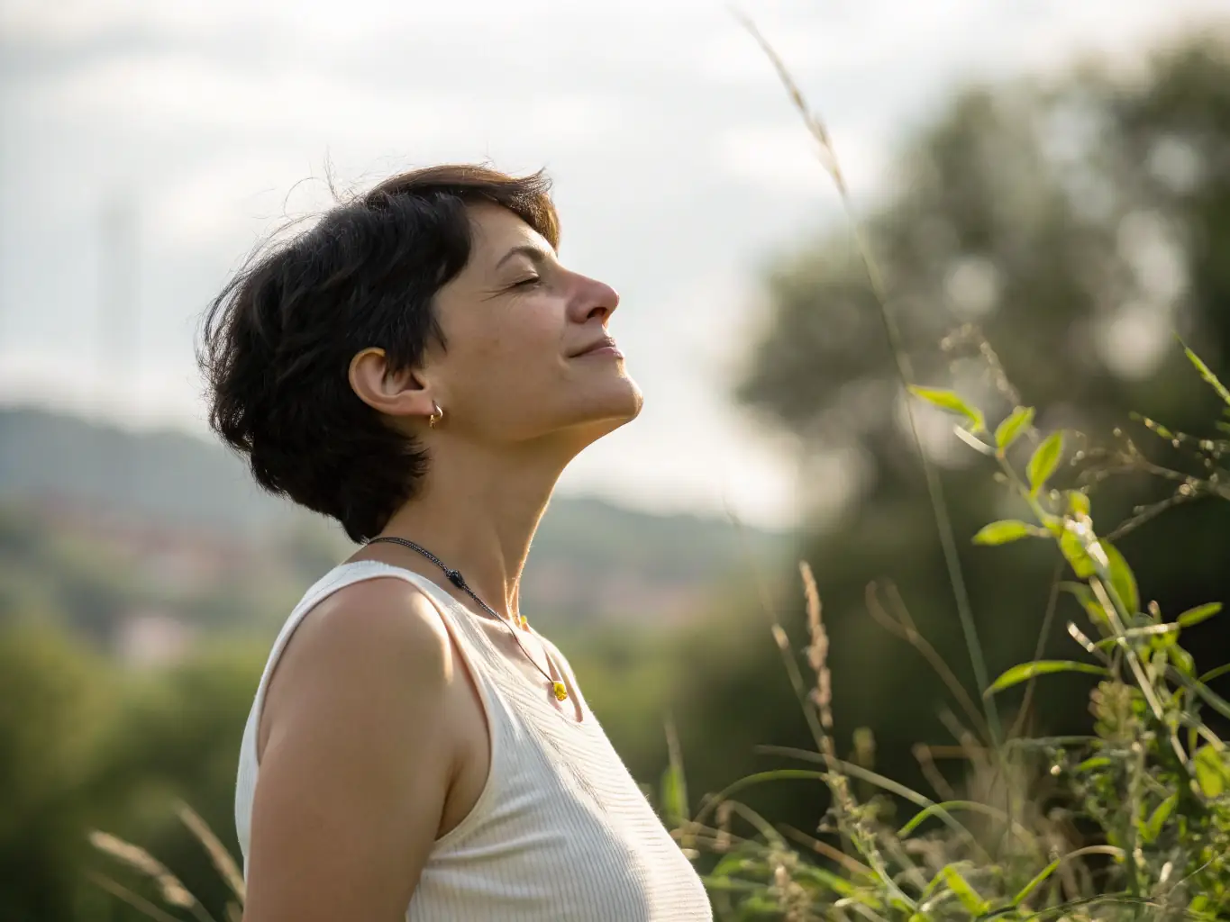A photograph showcasing natural, textured hairstyles with effortless waves and curls, emphasizing volume and movement, set in a sunlit outdoor setting.